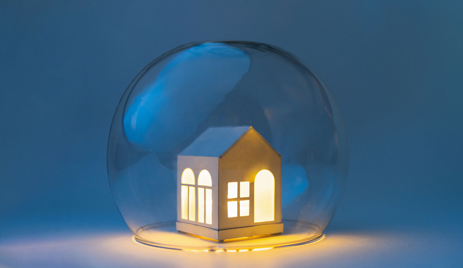 illuminated model of a house underneath a protective glass dome