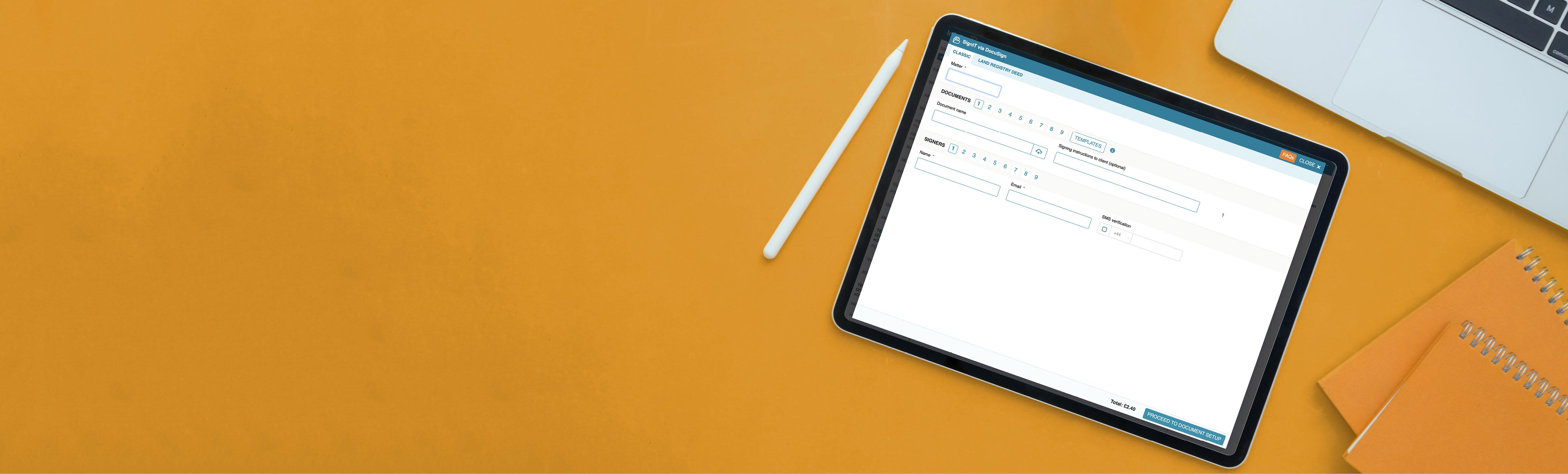 overhead view of yellow desktop with tablet showing InfoTrack's SignIt software and a stylus