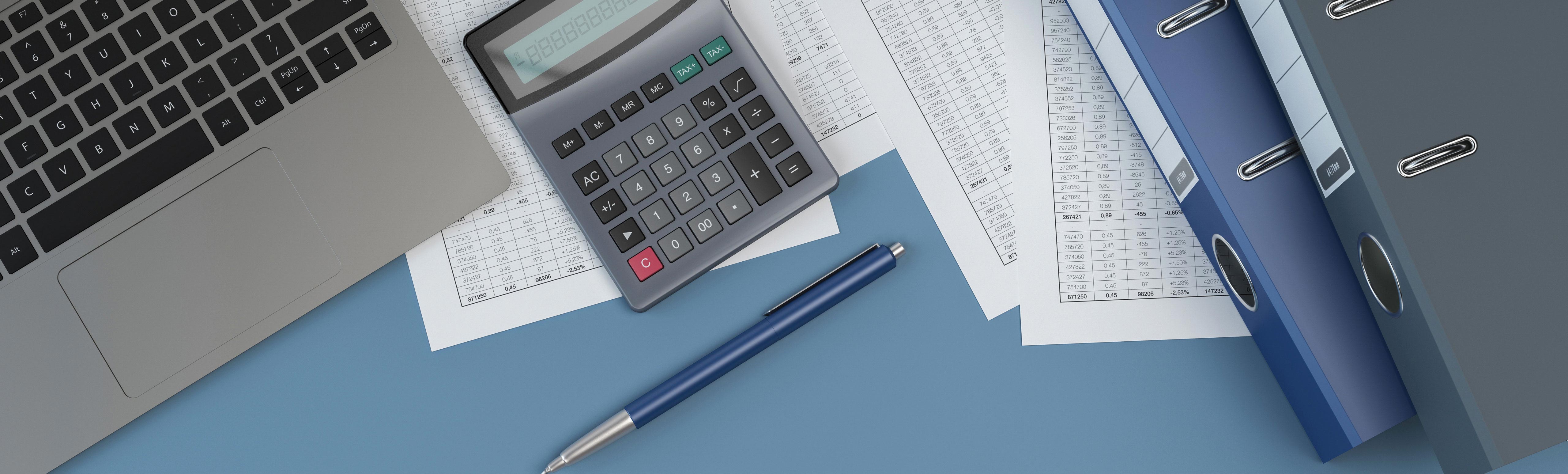 overhead desk view of macbook, pen, calculator, folders, spreadsheet printouts