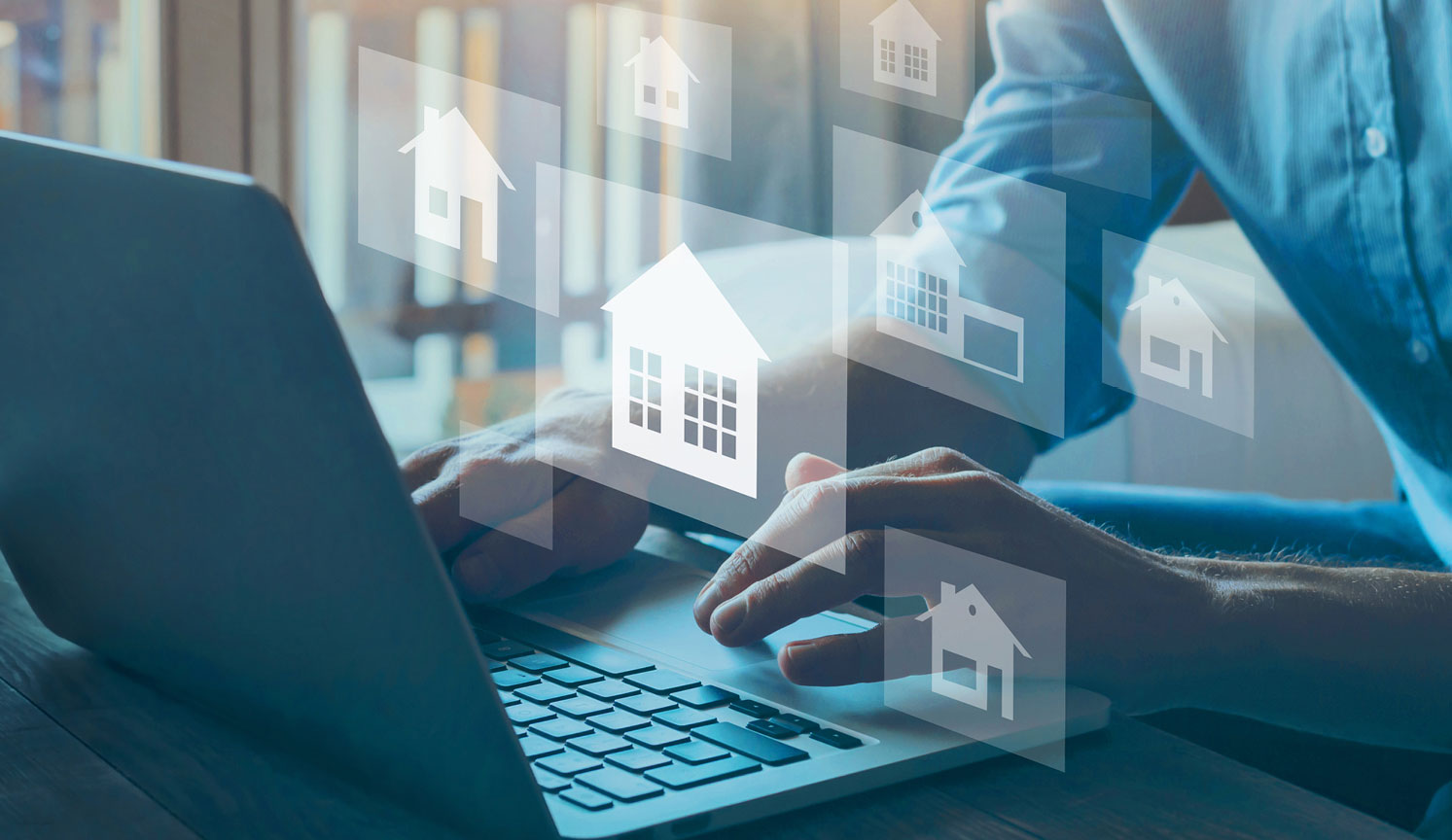 hands using a laptop with house graphics overlaid on top